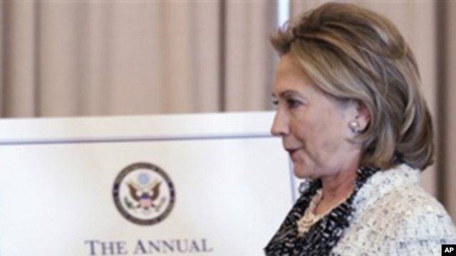Secretary of State Hillary Rodham Clinton walks past a portrait of the late Ambassador Richard Holbrooke, Friday, Jan. 14, 2011, at the State Department in Washington.