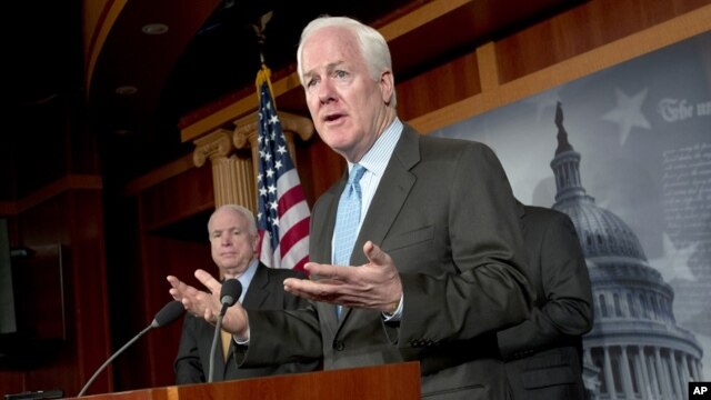  Sen. John Cornyn, R-Texas, right, accompanied by Sen. John McCain, R-Ariz., gestures during a news conference on Capitol Hill in Washington, Tuesday, June 26, 2012