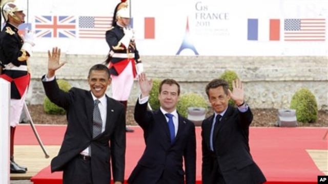 From left, US President Barack Obama, Russian President Dmitry Medvedev and French President Nicolas Sarkozy wave as they arrive for a lunch meeting at the Villa le Cercle during the G8 summit in Deauville, France, Thursday, May 26, 2011. G8 leaders, in a