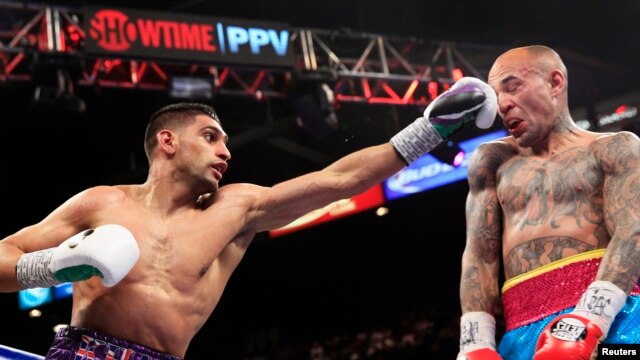 Amir Khan (L) of Britain punches Luis Collazo of the U.S. during their fight in Las Vegas, Nevada, May 3, 2014. (FILE) 