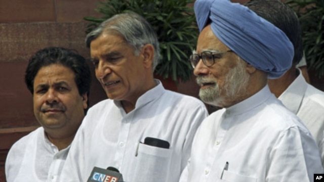 India's Prime Minister Manmohan Singh (R) speaks to the media as Minister of State for Parliamentary Affairs Rajiv Shukla (L) and Parliamentary Affairs Minister Pawan Kumar Bansal watch on the opening day of the monsoon session of the Indian Parliament in