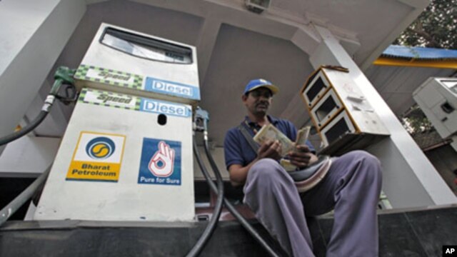 A worker counts Indian currency at a fuel station in Mumbai, India, 30 Dec 2010