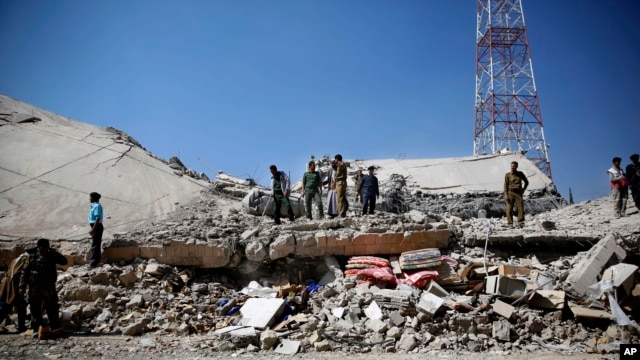 FILE - Policemen gather at the site of a Saudi-led airstrike on the police headquarters in Sana'a, Yemen, Jan. 18, 2016.