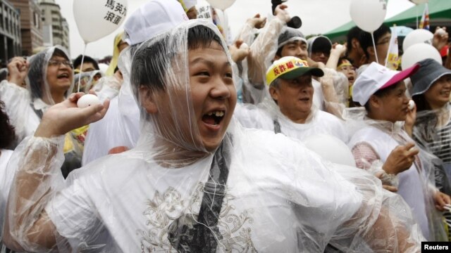Protesters throw eggs at a portrait of Taiwan's President Ma Ying-jeou during a demonstration in Taipei, May 20, 2012.