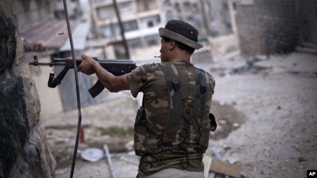 A Free Syrian Army fighter fires his weapon at Syrian Army positions in Aleppo, Syria, September 11, 2012. 