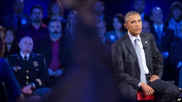 President Barack Obama watches the replay of his emotional speech from earlier this week during a CNN televised town hall meeting at George Mason University in Fairfax, Va., Thursday, Jan. 7, 2016.