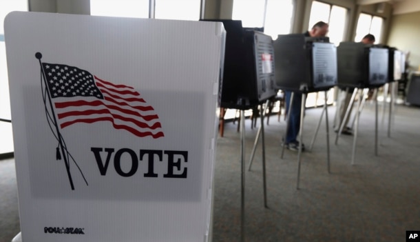 FILE - Voters cast ballots in the Illinois primary in Hinsdale, Ill., March 18, 2014. Illinois' top election officials insist that a recent hack into state voter rolls, which contain the names of 8 million active voters, does not pose a threat to the Nov. 8 election.