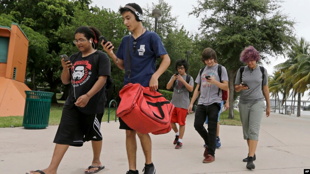 jovens andando com o celular na mão