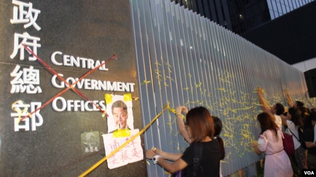 学生和市民在政总东侧公民广场铁栅栏上系黄丝带表真普选诉求（美国之音海彦拍摄 ）
