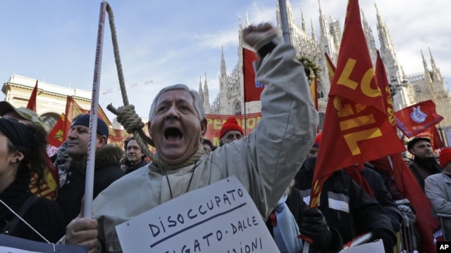 A protester wearing a sign reading "unemployed" shouts slogans during a metalworkers protest in front of the Duomo gothic cathedral, in Milan, Italy, December 5, 2012.