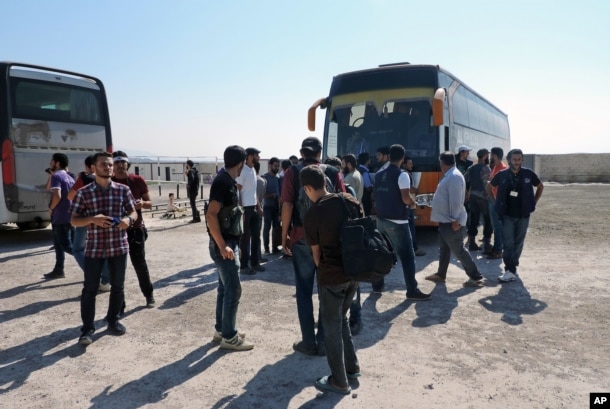 Rebels and their families arrive from the Damascus suburb of Daraya following a forced evacuation deal struck with the Syrian government that ends a grueling bombing campaign and four-year siege, in Babiska, Idlib province, Aug. 27, 2016.