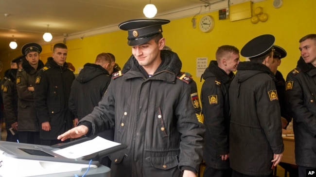 Un marinero militar ruso emite su voto durante la elección presidencial del domingo, 18 de marzo, de 2018, en Rusia.