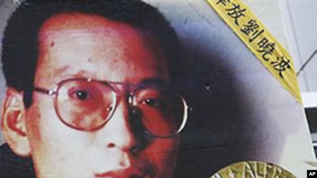 A picture of Chinese dissident Liu Xiaobo is carried by a protester during a rally demanding his release outside China's Liaison Office in Hong Kong, 11 Oct 2010