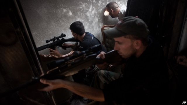 FSA soldiers scan for targets from within a bombed building in Saif Al Dula district in Aleppo, Syria, Monday, Sept. 10, 2012.