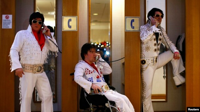 Amateur contestants (L-R) Phil Bailey, John Hindle and Eren Emir pose in telephone booths during the annual European Elvis Tribute Artist Contest and Convention in Birmingham, central England, Jan. 2, 2015.