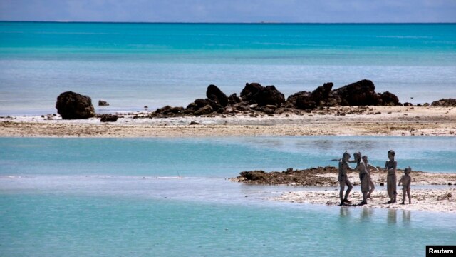 Trẻ em trên đảo South Tarawa, nước Cộng hòa Kiribati. Quốc gia này gồm 33 đảo san hô chỉ cao hơn mực nước biển 1 mét. Với tình trạng mực nước biển dâng lên, Tổng thống nước này tiên đoán nước ông sẽ không còn người ở trong 30 đến 60 năm vì nước ngập và ô nhiễm nguồn cung cấp nước ngọt