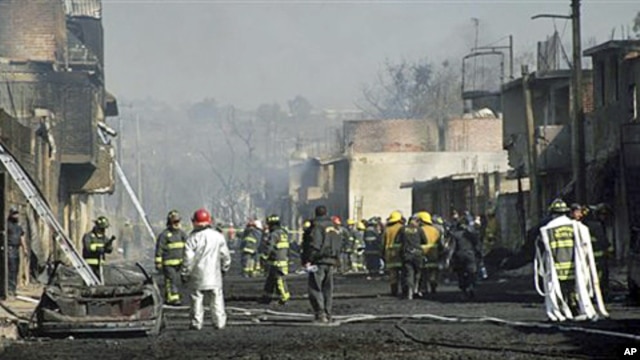 Emergency workers and firefighters work at the scene after a pipeline explosion in San Martin Texmelucan, Mexico, 19 Dec 2010