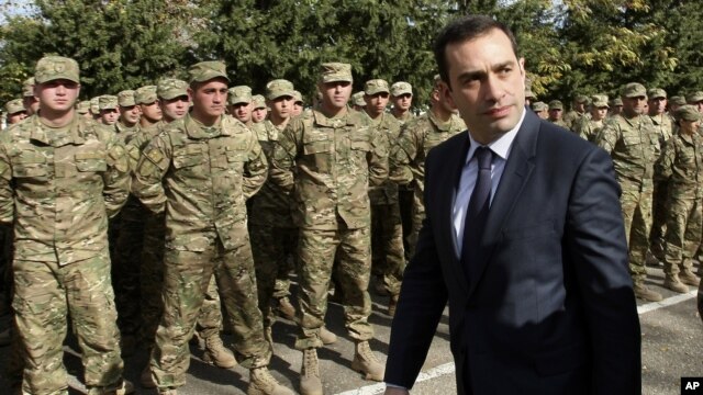 Georgian Defense Minister Irakli Alasania passes soldiers while visiting the Mukrovani military base, east of Tbilisi, Georgia, Nov. 7, 2012. 