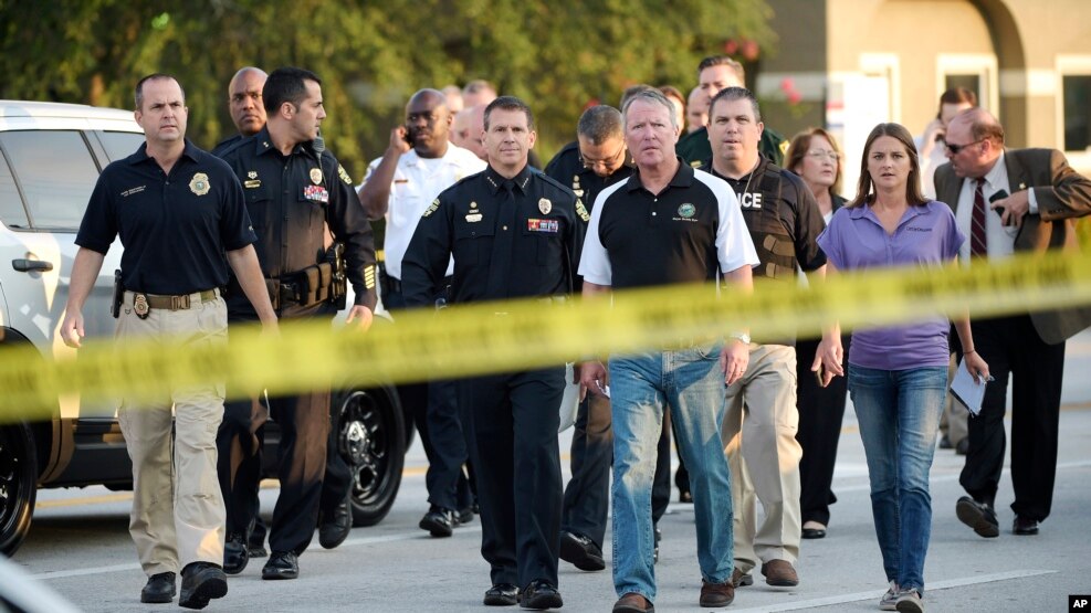 Meya wa Orlando Buddy Dyer, katikati, na mkuu wa polisi wa Orlando John Mina, kushoto, wawasili kuzungumza na waandishi habari kuhusu shambulizi la klabu ya Pulse Orlando Orlando, Fla., June 12, 2016.