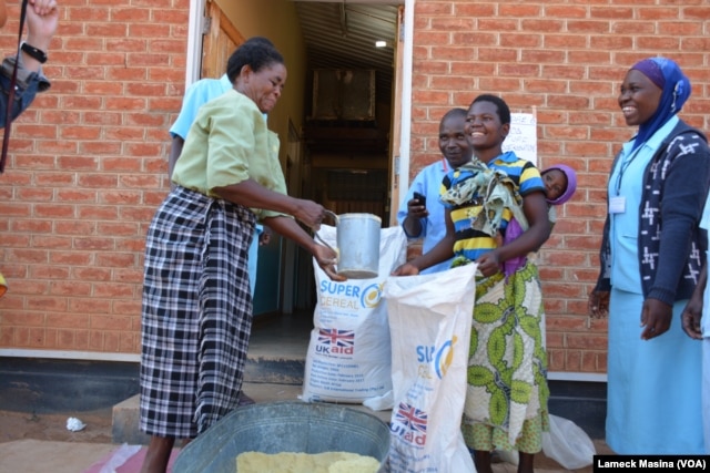 Women receive their share of 4.5 kilograms of soya flour at Mbela Health Center in Balaka distrcit, Malawi, under the WFP funded Supplementary Feeding Program.