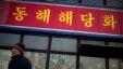 FILE - A man walks past a branch of the North Korean-operated Haedanghwa restaurant in Beijing. Officials did not say what country the group of defectors had been working in.