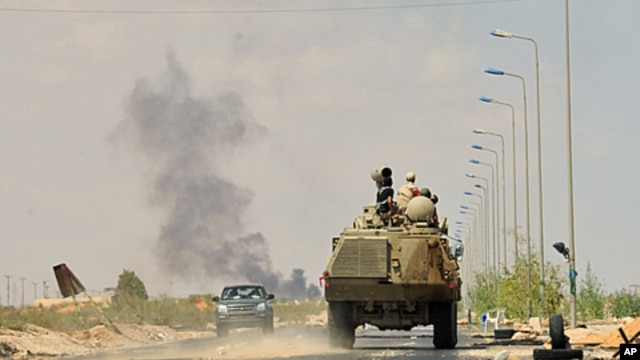 Anti-Gaddafi forces' armored personnel carrier advances to the front line at Teassain area, 90 km (56 miles) east of Sirte, amid heavy shelling by pro-Gaddafi forces, September 9, 2011.