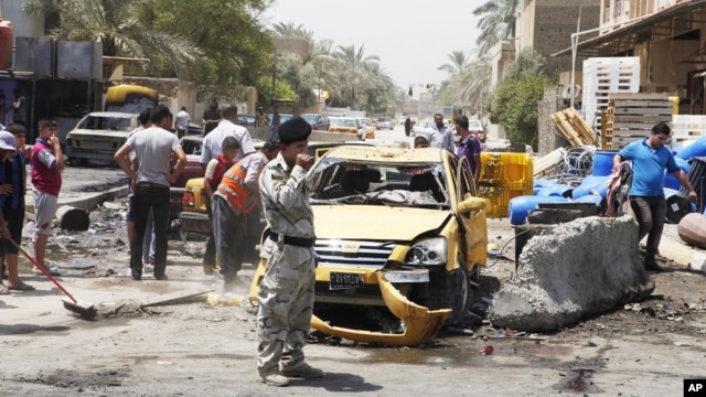 People inspect the aftermath of a car bomb attack in Baghdad's Shiite enclave of Sadr City, Iraq, July 23, 2012.