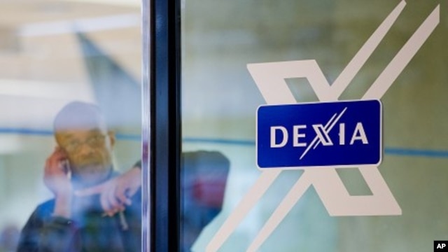 A man looks out of a door next to the Dexia logo at the corporate headquarters in Brussels, October 4, 2011.