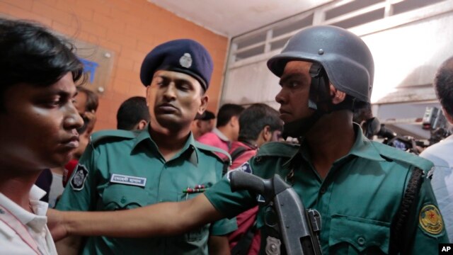 Cảnh sát Bangladesh ngăn đám đông bên ngoài một tòa nhà nơi 2 nhà hoạt động bênh vực người đồng giới tính đã bị sát hại tại Dhaka bởi một băng đảng mang mã tấu, ngày 25/4/2016.