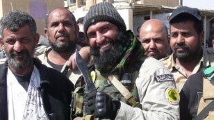 Ayyub Faleh al-Rubaie (C), known as Abu Azrael - Father of the Angel of Death - poses with Shiite fighters at the Speicher military base, near the northern Iraqi city of Tikrit, March 14, 2015.