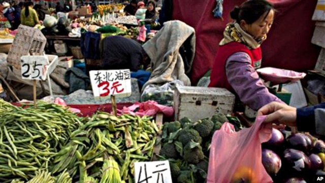A customer picks up a plastic bag of peppers at a fruit and vegetable market in Beijing (file photo - 17 Nov 2010)