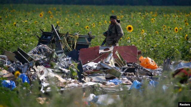 Một phần tử ly khai thân Nga đứng canh hiện trường nơi chuyến bay MH17 bị bắn rơi