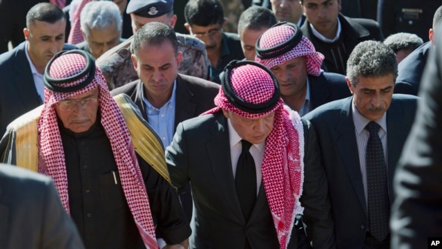 Quốc vương Abdullah II của Jordan (giữa) đi cùng với ông Safi al-Kaseasbeh (trái) thân phụ của viên phi công bị sát hại đến khu trại được dựng lên để tưởng niệm ông, 5/2/15