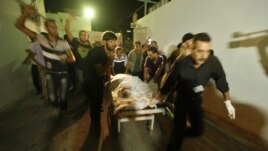 Palestinians wheel the body of a militant at a hospital, following an Israeli air strike in the northern Gaza Strip October 13, 2012.