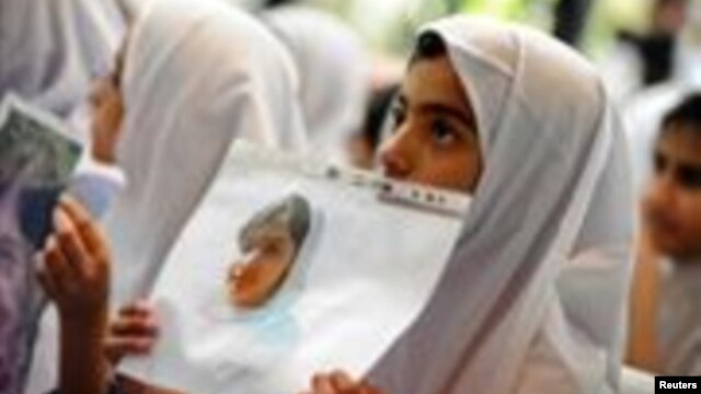 Students hold pictures of schoolgirl Malala Yousafzai, who was shot by the Taliban, during a tribute at the Pakistani Embassy in Abu Dhabi, October 15, 2012. 