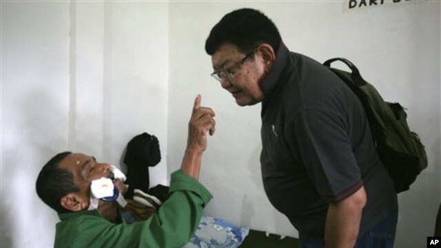 Maskut, 70, hendak memegang hidung Dr. Sanduk Ruit untuk membuktikan ia sudah bisa melihat setelah operasi mata. (AP/Binsar Bakkara)