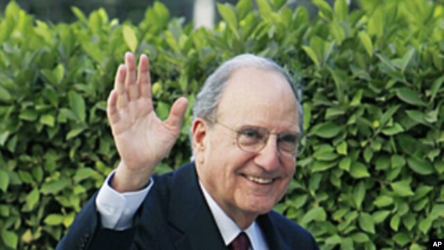 US Mideast envoy George Mitchell waves his hand to reporters while arriving at the Arab League headquarters in Cairo, Egypt, Dec. 15, 2010.