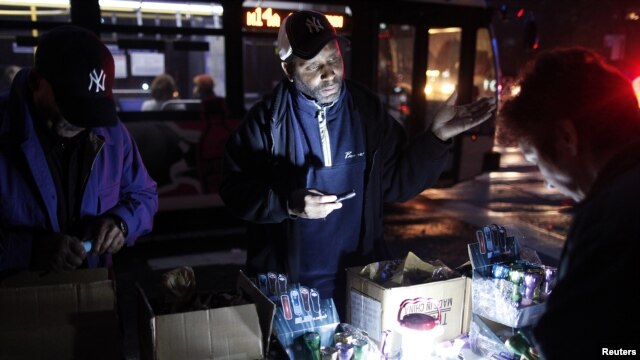 Un hombre vende linternas en Nueva York. Aún son miles los que no tienen fluido eléctrico.