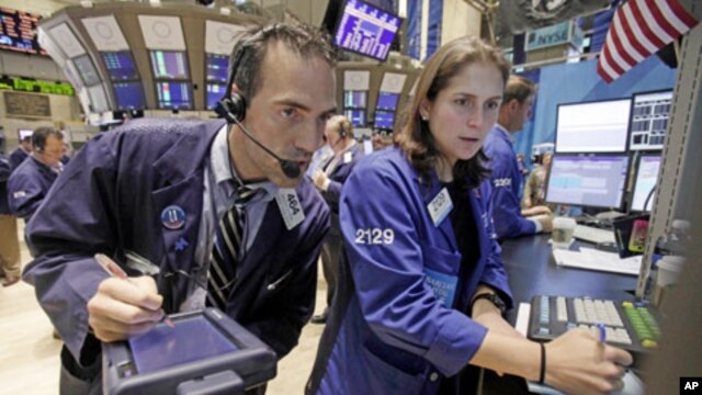 Trader Gregory Rowe and specialist Jennifer Klesaris work on the floor of the New York Stock Exchange, Friday, Aug. 12, 2011