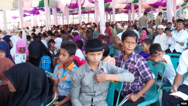 Warga Aceh Besar berkumpul di Pelabuhan Malahayati, lokasi yang terkena tsunami 2004, untuk memperingati sewindu gempa dan tsunami di Aceh. (VOA/Budi Nahaba)