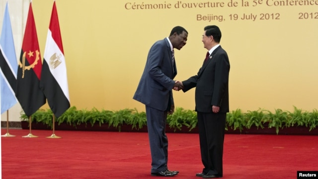China's President Hu Jintao (R) shakes hand with Benin's President Thomas Yayi Boni before a group photo session during the opening ceremony for the Fifth Forum on China-Africa Cooperation at the Great Hall of the People in Beijing, July 19, 2012.