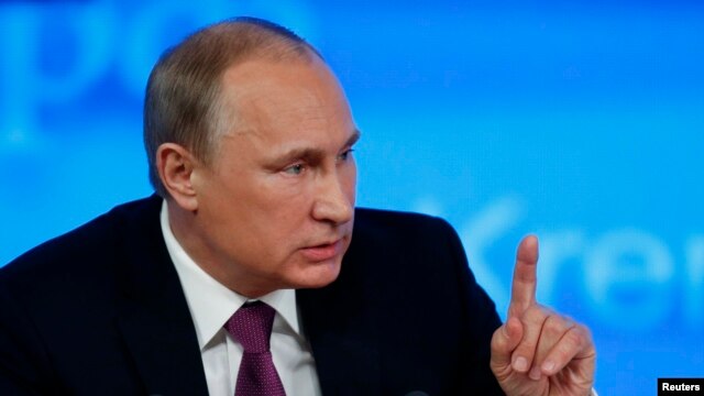FILE - Russian President Vladimir Putin, shown at a news conference, has signed a revised military doctrine listing NATO and the United States as national security threats.