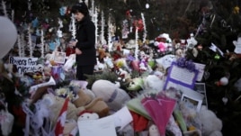 Jeanne Walker walks through an overflowing memorial to the shooting victims, Newtown, Connecticut, December 20, 2012.  