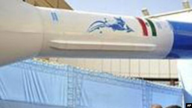 Iranian President Mahmoud Ahmadinejad, center, gestures towards a model of Iran's new domestically-built light booster rocket, named Simorgh, in Tehran, February 3, 2010