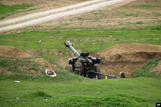 FILE - Armenian soldiers aim a howitzer, April 3, 2016, in the village of Mardakert, in the separatist region of Nagorno-Karabakh.