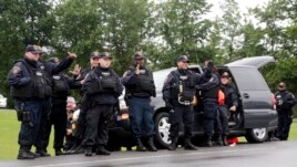 Cảnh sát vẫy chào người đi đường hoan hô họ sau khi David Sweat bị bắt giữ, ngày 28 tháng 6, 2015, ở thị trấn Constable, New York.
