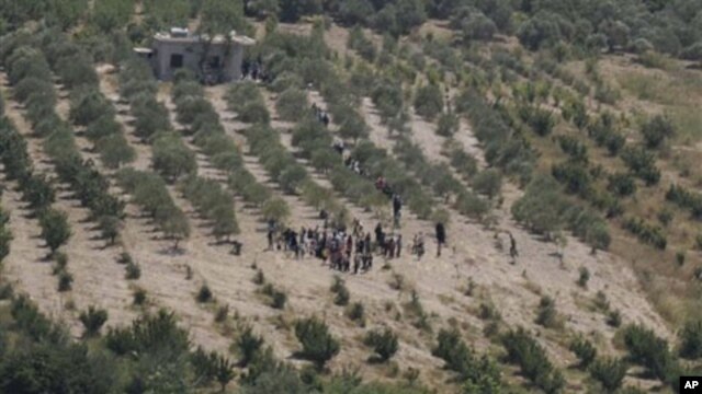 A group of Syrians head towards Turkey as they wait for the authorization to cross the border near Turkish village of Guvecci in Hatay province, Turkey, June 8, 2011