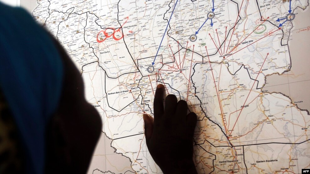 FILE - Evalina, a South Sudanese teenage victim of sexual abuse, points on a map to Unity state in South Sudan, indicating the location where she used to live, March 9, 2015. She said she escaped to Khartoum after being imprisoned by gunmen and sexually abused.
