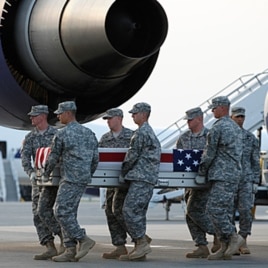 An Army carry team carries the transfer cases containing the remains of Army Spc. Scott D. Smith of Indianapolis, Indiana upon arrival at Dover Air Force Base, Delaware on June 21, 2011.