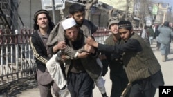 Afghans carry a wounded man during an anti-U.S. demonstration in Kunduz, north of Kabul, Afghanistan, Saturday, Feb. 25, 2012.